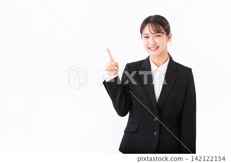 一位身穿西裝的年輕女子指著別人。 一位身穿西裝的年輕女子指著別人。 142122154