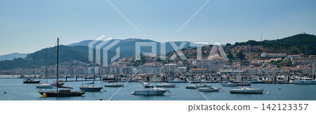 Panorama of the port of Baiona with anchored sailboats and the town on the hillside Panorama of the port of Baiona with anchored sailboats and the town on the hillside 142123357