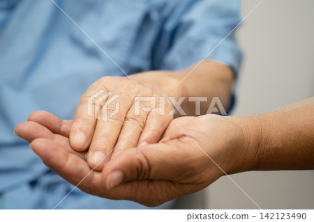 Caregiver holding hands Asian elderly woman patient, help and care in hospital. Caregiver holding hands Asian elderly woman patient, help and care in hospital. 142123490