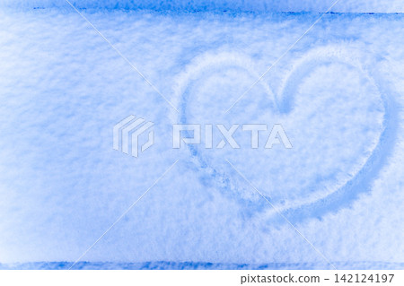 A heart shape drawn in fresh snow and a pale blue snowscape A heart shape drawn in fresh snow and a pale blue snowscape 142124197
