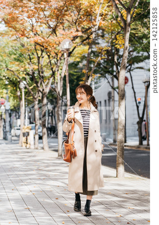 A woman wearing a trench coat and bra in the city A woman wearing a trench coat and bra in the city 142125858