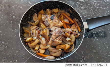 Homemade beef steak fried with vegetables in a pan 142126201