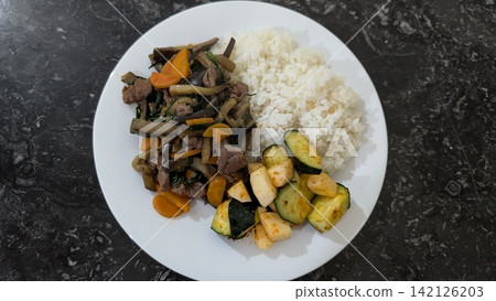 Homemade meat and vegetable stir fry with rice 142126203