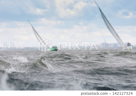 magic splashing water, Russia, St.Petersburg, Yachtsmen are sitting amicably on board of the sailing boat in sailing regatta in the Gulf of Finland at sunny day, teamwork magic splashing water, Russia, St.Petersburg, Yachtsmen are sitting amicably on board of the sailing boat in sailing regatta in the Gulf of Finland at sunny day, teamwork 142127324