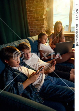 Children using smartphones and laptop together in connected home setting Children using smartphones and laptop together in connected home setting 142128195