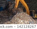Industrial conveyor belt unloading processed organic waste pile in recycling power plant warehouse. 142128267