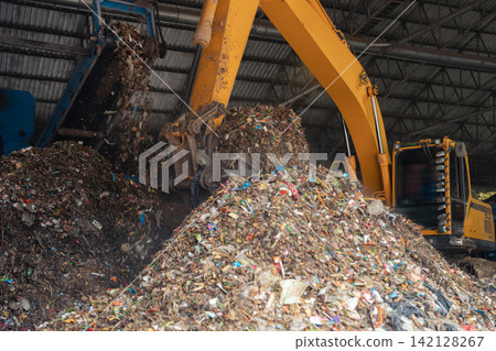 Industrial conveyor belt unloading processed organic waste pile in recycling power plant warehouse. Industrial conveyor belt unloading processed organic waste pile in recycling power plant warehouse. 142128267