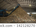 Huge pile of sorted municipal solid waste under conveyor belt in recycling facility hall. 142128270