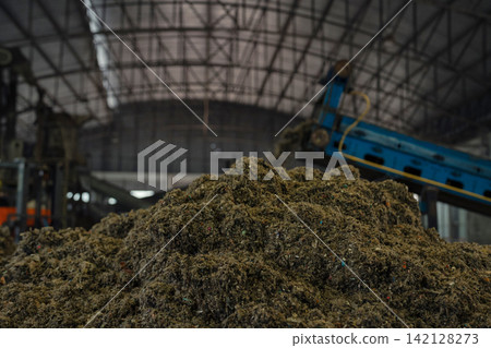 Huge pile of sorted municipal solid waste under conveyor belt in recycling facility hall. Huge pile of sorted municipal solid waste under conveyor belt in recycling facility hall. 142128273