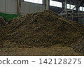 Huge pile of sorted municipal solid waste under conveyor belt in recycling facility hall. 142128275