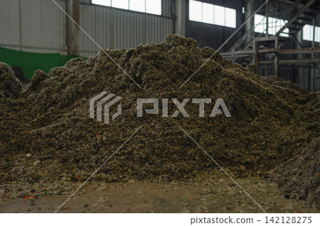 Huge pile of sorted municipal solid waste under conveyor belt in recycling facility hall. Huge pile of sorted municipal solid waste under conveyor belt in recycling facility hall. 142128275