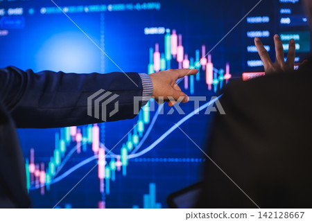 Business person pointing at a stock market chart on a screen during a financial meeting Business person pointing at a stock market chart on a screen during a financial meeting 142128667
