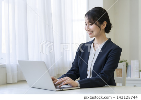 一位 30 多歲的女商人在筆記本電腦上工作 一位 30 多歲的女商人在筆記本電腦上工作 142128744
