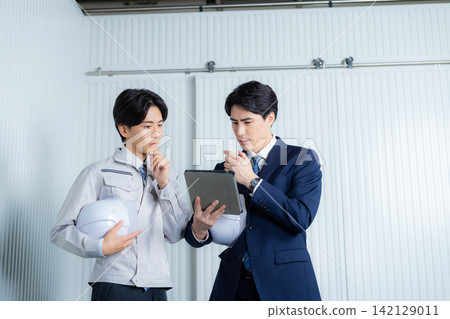 一個穿西裝的男人和一個工人 142129011