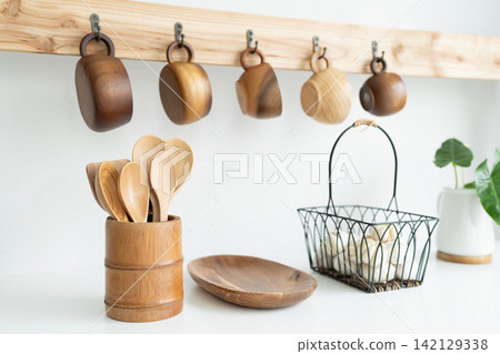 Wooden cup hanging, wooden utensil and garlic in a basket Wooden cup hanging, wooden utensil and garlic in a basket 142129338