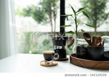 Coffee and moka pot set arranged on white table, morning relaxing routine Coffee and moka pot set arranged on white table, morning relaxing routine 142129339