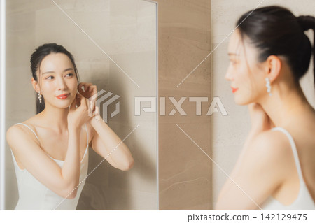 穿著白色洋裝的年輕女子 穿著白色洋裝的年輕女子 142129475