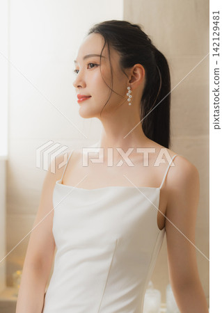 young woman in a white dress young woman in a white dress 142129481