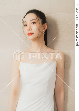 young woman in a white dress young woman in a white dress 142129482