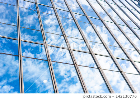 Low angle view of modern glass office building facade reflecting cloudy sky in Fukuoka, Japan Low angle view of modern glass office building facade reflecting cloudy sky in Fukuoka, Japan 142130776
