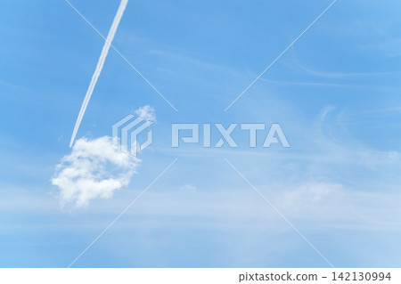 A contrail stretching straight across the blue sky, and white clouds. A contrail stretching straight across the blue sky, and white clouds. 142130994