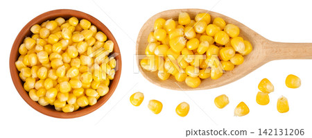 corn seeds in ceramic bowl and wooden spoon isolated on white background. Top view. Flat lay corn seeds in ceramic bowl and wooden spoon isolated on white background. Top view. Flat lay 142131206