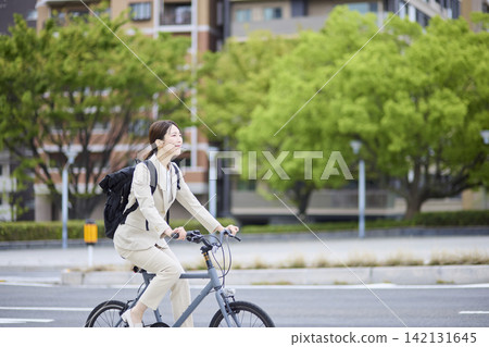 一位職業婦女騎自行車行駛在路上 一位職業婦女騎自行車行駛在路上 142131645