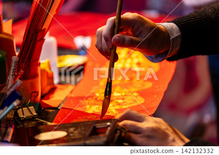 Hands writing Lunar New Year calligraphy Hands writing Lunar New Year calligraphy 142132332