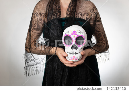 Day of the Dead Calavera Portrait with Hand-Painted Sugar Skull in Copy Space Day of the Dead Calavera Portrait with Hand-Painted Sugar Skull in Copy Space 142132410