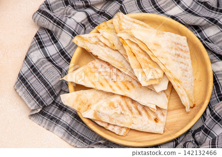 Grilling thin triangular envelopes of dough with filling. Flatbread food. Grilling thin triangular envelopes of dough with filling. Flatbread food. 142132466