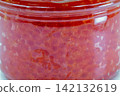 Red caviar in glass jar macro closeup on white. 142132619