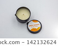 Sweet orange massage candle product closeup on white. 142132624