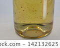 Wine sediment in bottle of white wine, closeup on white. 142132625