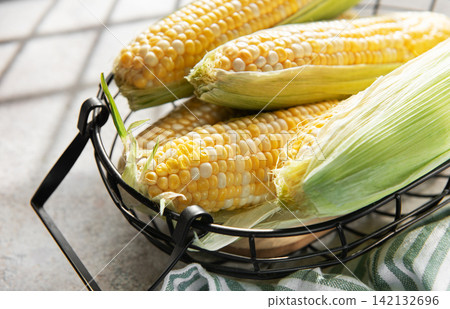 Fresh corn on the cob in basket for cooking Fresh corn on the cob in basket for cooking 142132696
