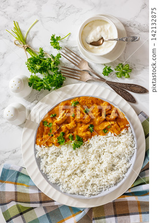 Butter chicken with fluffy basmati rice on plate Butter chicken with fluffy basmati rice on plate 142132875