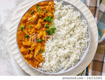 Butter chicken with fluffy basmati rice on plate Butter chicken with fluffy basmati rice on plate 142132881