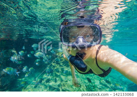 Woman snorkeling underwater in the tropical Caribbean sea, wearing mask and snorkel while exploring coral reef, clear blue water and marine life concept Woman snorkeling underwater in the tropical Caribbean sea, wearing mask and snorkel while exploring coral reef, clear blue water and marine life concept 142133068