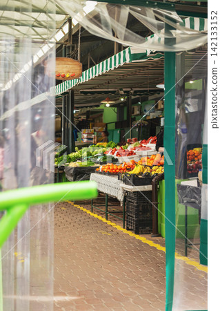 Fresh Fruits and Vegetables at Local Farmers Market Stall seen through transparent curtains. Organic tomatoes, oranges, lettuce, seasonal produce. Colorful food market, healthy eating, local produce Fresh Fruits and Vegetables at Local Farmers Market Stall seen through transparent curtains. Organic tomatoes, oranges, lettuce, seasonal produce. Colorful food market, healthy eating, local produce 142133152
