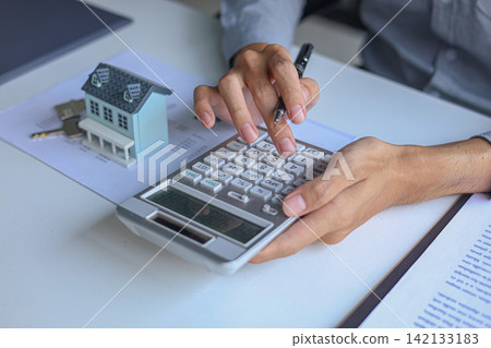 Close-up hand calculating and review documents for property investment, financial planning and home loan campaigns. Close-up hand calculating and review documents for property investment, financial planning and home loan campaigns. 142133183