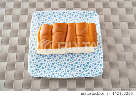 A gentle morning with fluffy bread rolls and a patterned plate. A gentle morning with fluffy bread rolls and a patterned plate. 142133296
