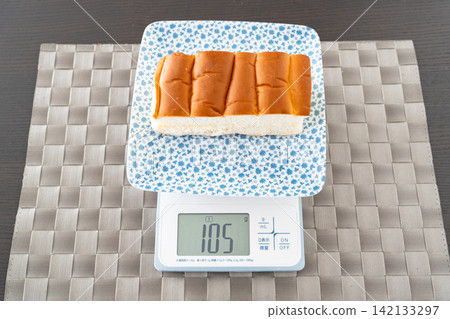 圖中展示了稱量麵包捲和管理食材的過程。 142133297