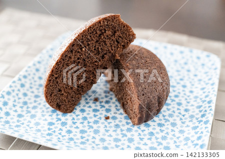 A moist and rich chocolate steamed bun, gently sliced. A moist and rich chocolate steamed bun, gently sliced. 142133305
