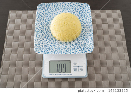 A round, puffy, yellow steamed bun A round, puffy, yellow steamed bun 142133325