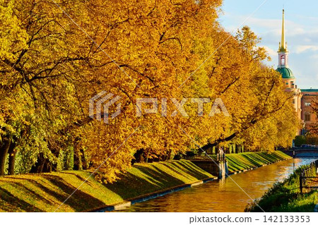Lebyazhya kanavka embankment to the engineering palace, Trees with yellow leaves of the Summer garden in sunny autumn evening, Russia, Saint Petersburg 142133353