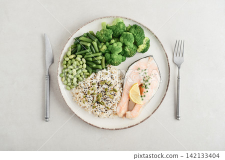 Balanced healthy meal with baked salmon with brown rice and vegetables 142133404