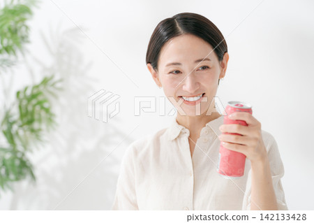 A woman drinking a canned beverage A woman drinking a canned beverage 142133428