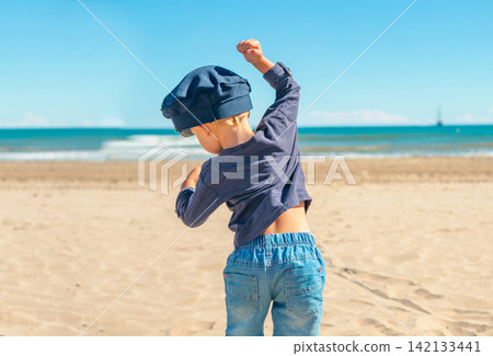 Children express different emotions while playing by the sea on a sunny day Children express different emotions while playing by the sea on a sunny day 142133441