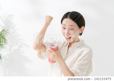 一名女子擺出勝利姿勢,喝起了飲料。 一名女子擺出勝利姿勢,喝起了飲料。 142133475