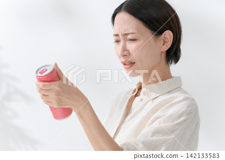 一名女子正在喝罐裝飲料 一名女子正在喝罐裝飲料 142133583