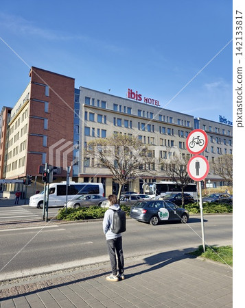 Krakow, Poland - April 22, 2026: Ibis Hotel Buildings, Traffic and Pedestrian on City Street Krakow, Poland - April 22, 2026: Ibis Hotel Buildings, Traffic and Pedestrian on City Street 142133817